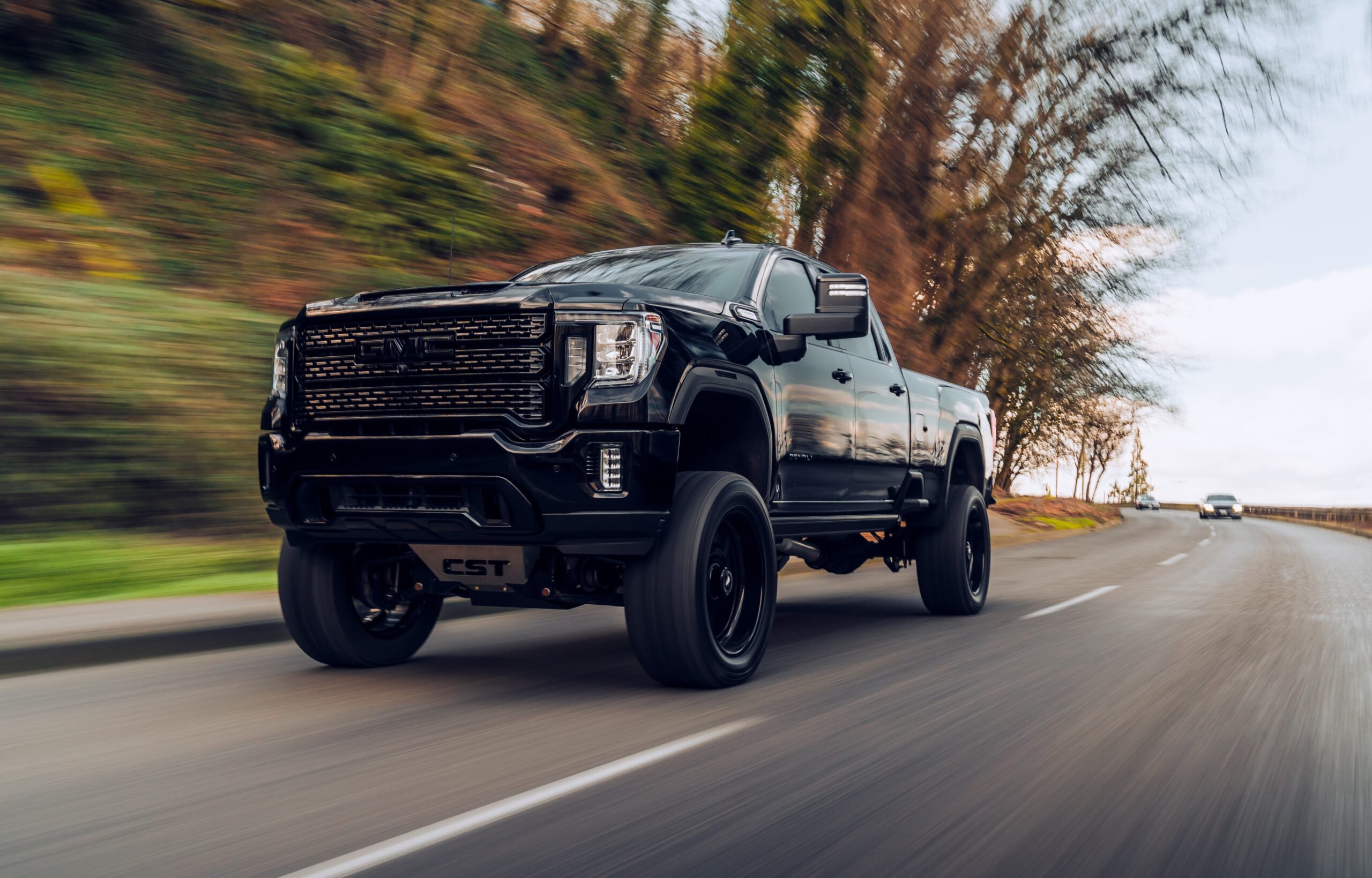 lifted pick up truck driving down the road